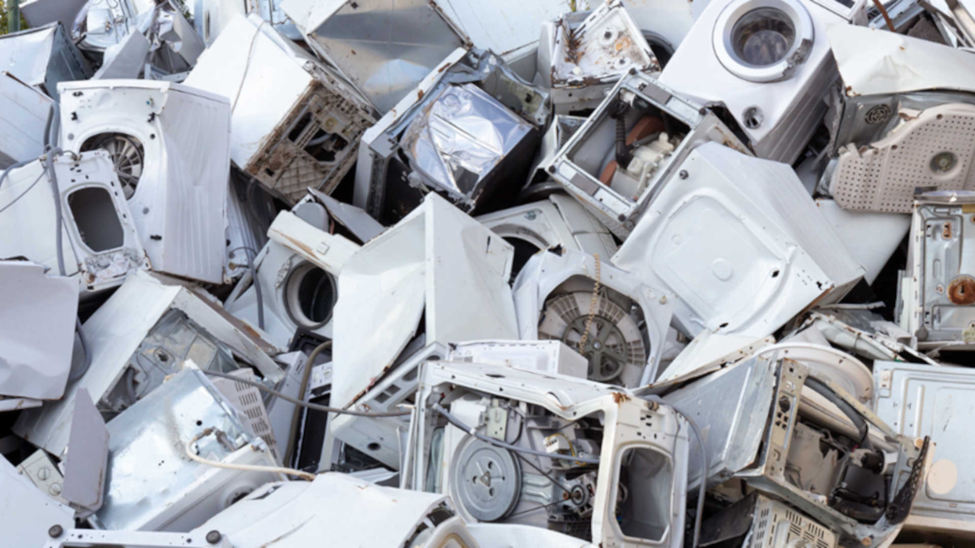 Whiteware disposal – pile of scrap white laundry machines ready for whiteware recycling.